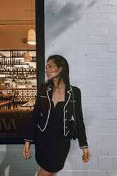 a lady wears a black cropped jacket with a black mini dress